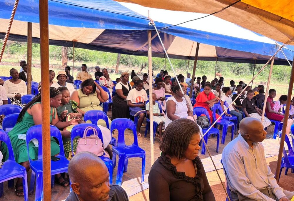 Congregation seated under the blue and yellow tent